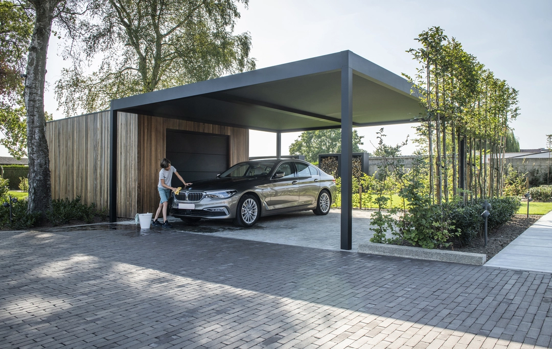 Enfant nettoyant une voiture sous un carport double